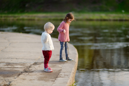 Two cute sisters by a river at summerの写真素材