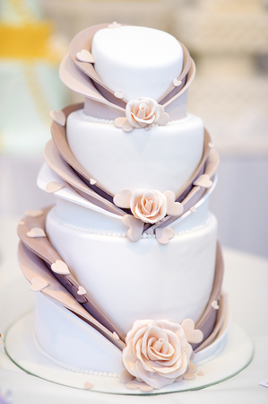 White wedding cake decorated with beige sugar flowersの写真素材