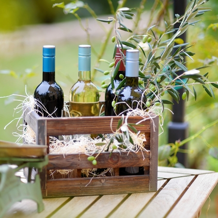 Wine bottle in a vintage wooden crate decorated with olive branchesの写真素材