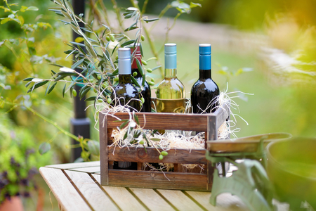 Wine bottle in a vintage wooden crate decorated with olive branchesの写真素材