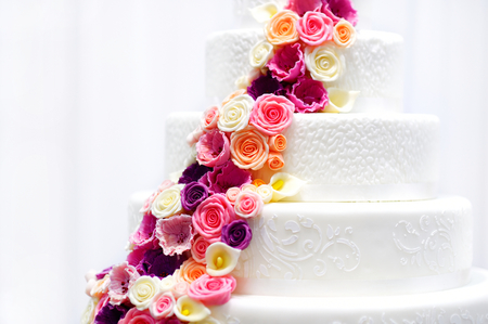 Detail of a white wedding cake decorated with pink sugar flowersの写真素材