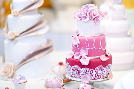 White wedding cake decorated with pink sugar flowersの写真素材
