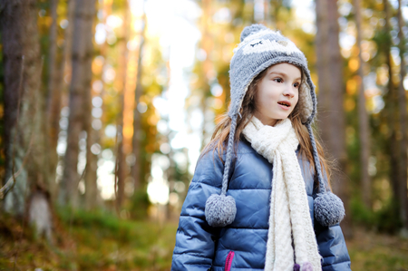 Adorable little girl hiking in forest on beautiful autumn dayの写真素材