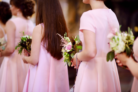 Row of bridesmaids with bouquets at wedding ceremonyの写真素材