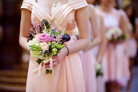 Row of bridesmaids with bouquets at wedding ceremonyの写真素材