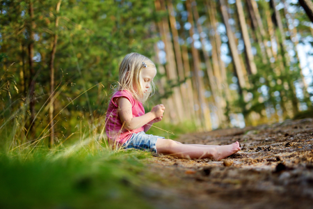 Adorable little girl hiking in the forest on hot summer dayの写真素材