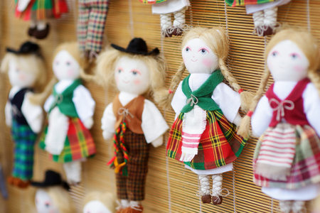 Cute handmade ragdoll dolls in Lithuanian national costumes sold on Easter market in Vilnius. Lithuanian capital's annual traditional crafts fair is held every March on Old Town streets.の写真素材