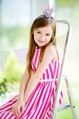 Portrait of adorable little girl wearing beautiful dress and a princess tiaraの写真素材