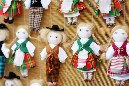 Cute handmade ragdoll dolls in Lithuanian national costumes sold on Easter market in Vilnius. Lithuanian capital's annual traditional crafts fair is held every March on Old Town streets.の写真素材