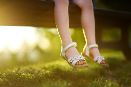 Close-up of little girl's legs on summer sunset outdoorsの写真素材