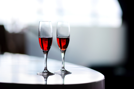 Two glasses of wine or another alcoholic beverage on a table for party, wedding reception or festive eventの写真素材