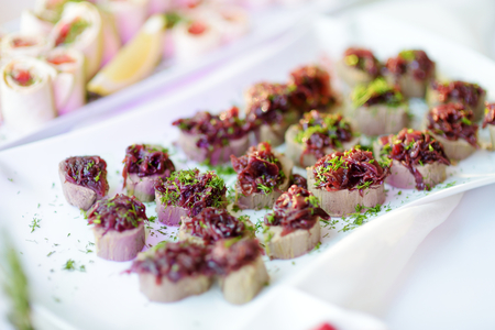 Delicious pate snacks with beet topping served on a party or wedding reception. Plates with assorted...