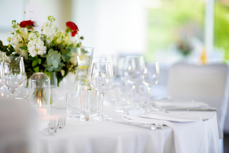 Beautiful table setting with crockery and flowers for a party, wedding reception or other festive event. Glassware and cutlery for catered event dinner.の写真素材