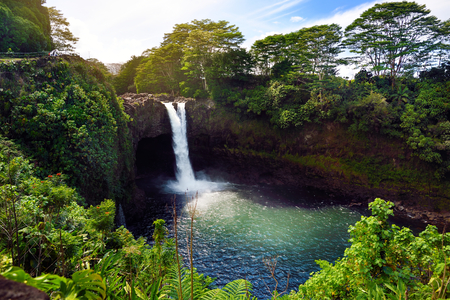Majesitc Rainbow Falls waterfall in Hilo, Wailuku River State Park, Hawaii. The falls flows over a natural lava cave, the mythological home to Hina, an ancient Hawaiian goddess.の写真素材