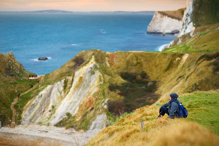 Tourist enjoying view of Man O'War Cove on the Dorset coast in southern England, between the...