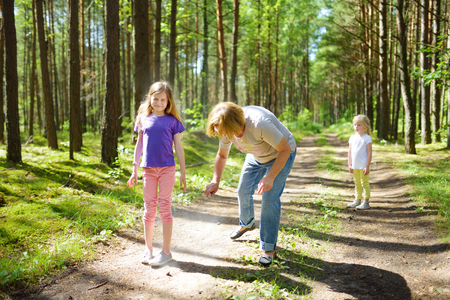 Middle age woman applying insect repellent to her granddaughter before forest hike beautiful summer day. Protecting children from biting insects at summer. Active leisure with kids.の写真素材