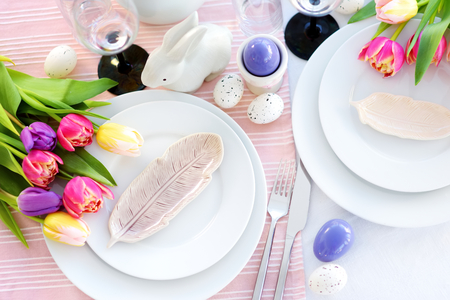 Beautiful table setting with crockery and flowers for Easter celebration. Glassware and cutlery for...