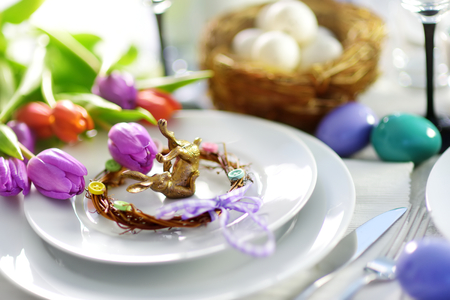 Beautiful table setting with crockery and flowers for Easter celebration. Glassware and cutlery for...