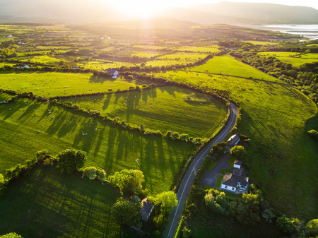 Aerial view of endless lush pastures and farmlands of Ireland. Beautiful Irish countryside with emerald green fields and meadows. Rural landscape on sunset.の写真素材