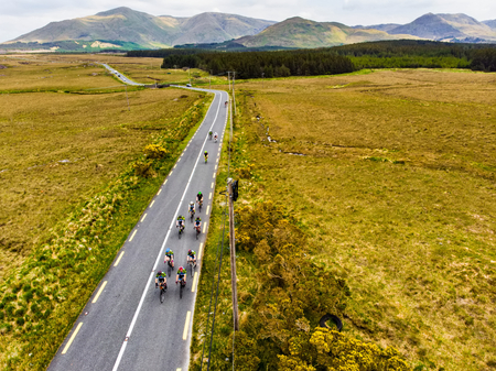Professional cyclists competing in Connemara region in Ireland. Scenic Irish countryside landscape...