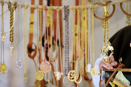 TRAKAI, LITHUANIA - JUNE 16, 2018: Copper necklaces sold on market stall during annual Medieval Festival, held in Trakai Peninsular Castle. Recreating medieval town spirit.のeditorial素材