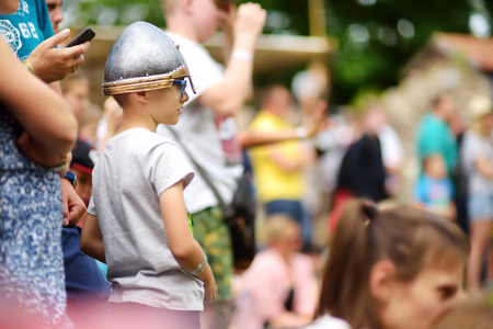 TRAKAI, LITHUANIA - JUNE 16, 2018: Kids and adults enjoying historical reenactment on annual Medieval Festival, held in Trakai Peninsular Castle. Visitors watching the jousting show.のeditorial素材