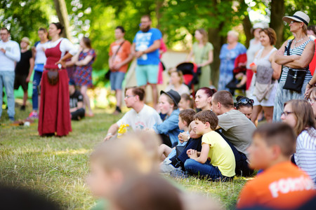 TRAKAI, LITHUANIA - JUNE 16, 2018: Kids and adults enjoying historical reenactment on annual Medieval Festival, held in Trakai Peninsular Castle. Visitors watching the jousting show.のeditorial素材