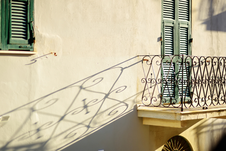 Metal balcony fence casting beautiful shadow on a wall in Riomaggiore, the largest of the five centuries-old villages of Cinque Terre, Liguria, Italy.の写真素材