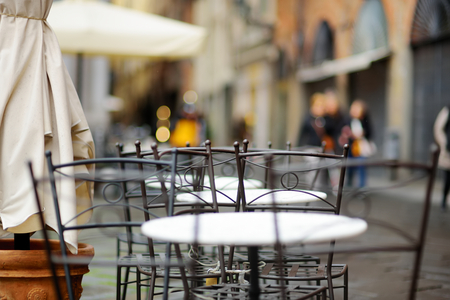 Empty small outdoor restaurant tables on the main square of Lucca, Tuscany, Italyの写真素材