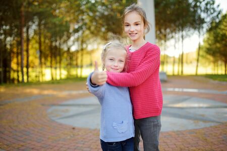 Two cute sisters having fun at the Geographical Centre of Europe, located in Lithuania, near the village of Girija. Family trips with kids.の写真素材