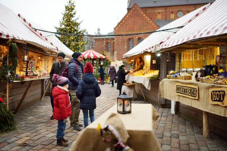 RIGA, LATVIA - DECEMBER 17, 2018: People enjoying the most authentic Christmas market in Riga and will offer dozens of crafts and food stalls, as well as a giant Christmas tree.のeditorial素材