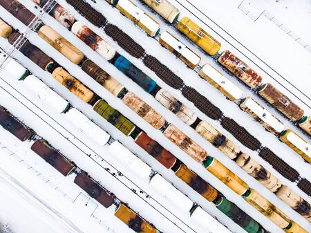 Aerial view of colorful freight train cars on the railway station. Wagons with goods on railroad. Heavy industry. Industrial conceptual scene with trains.の写真素材