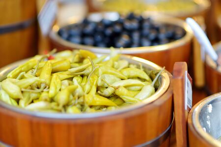 Assorted organic pickled olives, garlic, hot peppers, capers and sundried tomatos sold on a...