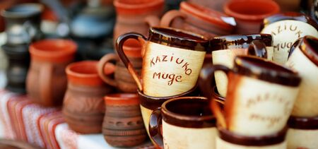 Ceramic dishes, tableware and jugs sold on Easter market in Vilnius. 'Kaziuko muge' means 'Kaziukas fair' in Lithuanian. Annual traditional crafts fair is held every March on Old Town streets.の写真素材
