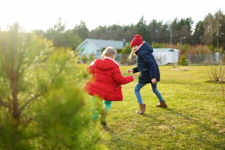 Two cute young sisters having fun together on beautiful spring day. Active family leisure with kids....