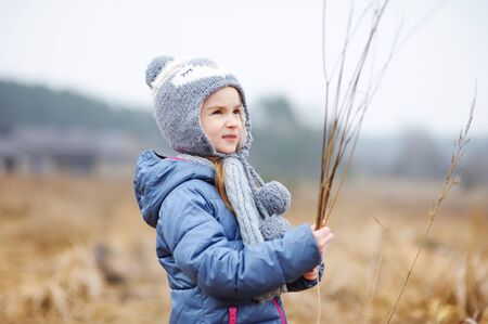 Cute little girl having fun during forest hike on beautiful spring day. Child exploring wild nature. Active family leisure with kids.の写真素材
