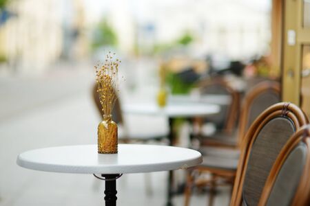 Outdoor restaurant table beautifully decorated with plants and flowers in Vilnius, Lithuania, on nice summer day.の写真素材