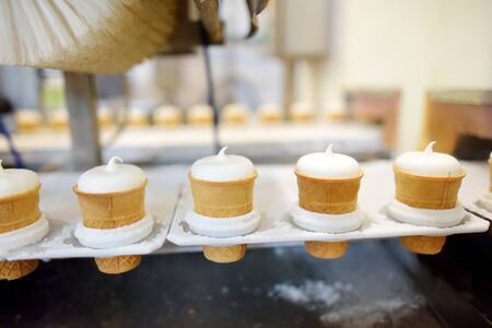 Close-up shot of moving conveyer with ice-cream cones ready for packing. Frozen desserts production...