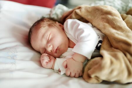 Cute little newborn baby boy sleeping on white blanket. Portrait of tiny new baby at home. New bundle of joy.の写真素材