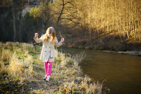 Cute young girl having fun on beautiful sunny spring day. Active family leisure with kids. Family...