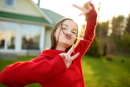 Pretty teenage girl blowing soap bubbles on a sunset. Child having fun in a park in summer. Funny activities for kids.の写真素材
