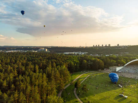 VILNIUS, LITHUANIA - JULY 3, 2020: Colorful hot air balloons taking off in Vingis park in Vilnius city on sunny summer evening. Lots of people watching as balloons fly away.のeditorial素材