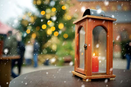 Lantern as a decoration of a wooden table on Christmas market in Riga, Latvia. Decorated and illuminated shopping stands with variety of Xmas toysの写真素材