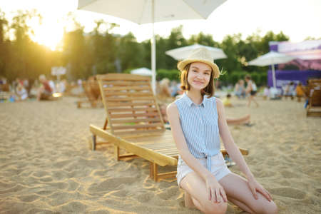 Adorable teenage girl having fun on city beach on Lukiskes square in Vilnius.の写真素材