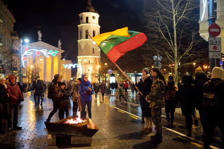 VILNIUS, LITHUANIA - FEBRUARY 16, 2020: Hundreds of people attending the celebration of Restoration of the State Day in Vilnius. Bonfires are lit on Gediminas avenue on festive night on February 16.のeditorial素材