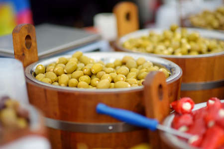 Assorted organic pickled olives, garlic, hot peppers, capers and sundried tomatos sold on a marketplace in Vilnius, Lithuania, during Kaziukas, traditional spring fair.の写真素材