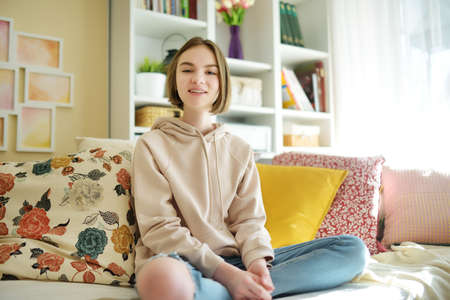 Beautiful teenage girl recording a video blog. Young vlogger shooting vlog at home. Teen influencer creating content for her social media account. Social media and blogging concept.の写真素材