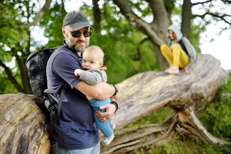 Family of three exploring the Dubingiai Castle Hill, former island, now a peninsula, located by Lake Asveja, the longest lake in Lithuania. Cognitive trail through archaeological and natural sites.の写真素材