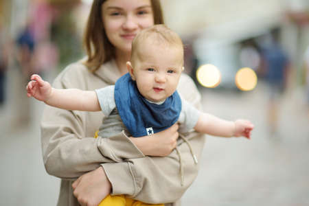 Cute big sister admiring her baby brother. Adorable teenage girl holding her new baby boy brother. Kids with large age gap. Big age difference between siblings. Big family.の写真素材