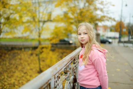 Cute young girl having fun on beautiful sunny autumn day. Active family leisure with kids. Family fun outdoors.の写真素材